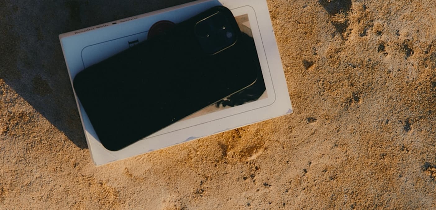Phone and book on sand